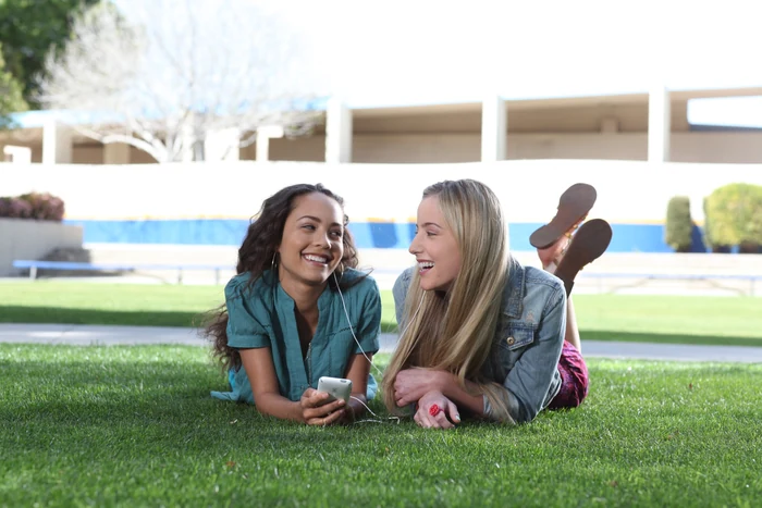 Two young patients laughing together on the grass